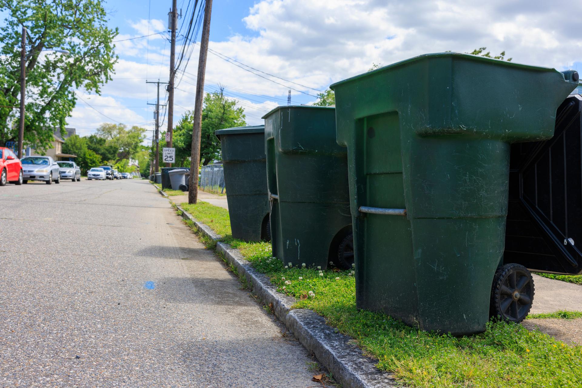 Recycling garbage in suburban area. Close up green wheeled garbage cans in the street. Hampton, VA